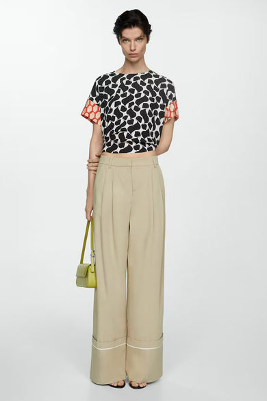 Blouse à manches courtes multicolore de MANGO, à motif graphique noir et blanc, avec manches à motif géométrique rouge.