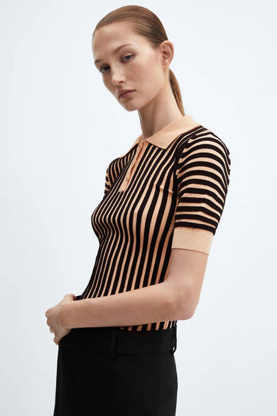 Polo rayé marron et abricot de MANGO, porté avec un pantalon noir uni.
