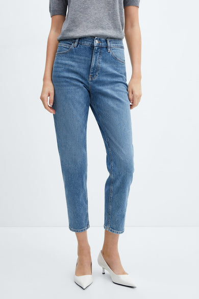 Mid blue mom jeans with high waist and cropped straight legs, worn with gray top and white heels, front view