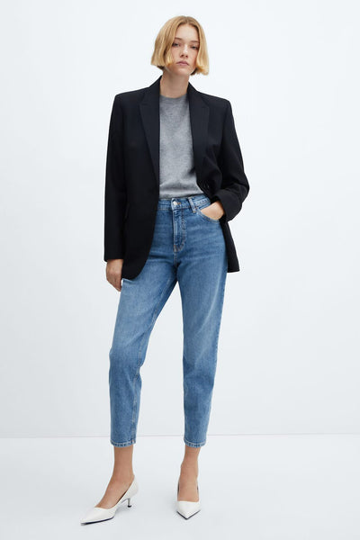 Mid blue denim mom jeans by Newmom, straight-leg cropped fit with classic five-pocket styling, worn with black blazer and white heels in full-length front view.
