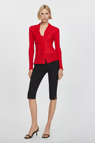 Chemisier rouge à manches courtes de MANGO, avec volants décoratifs, porté avec un pantacourt noir et des sandales à talons.
