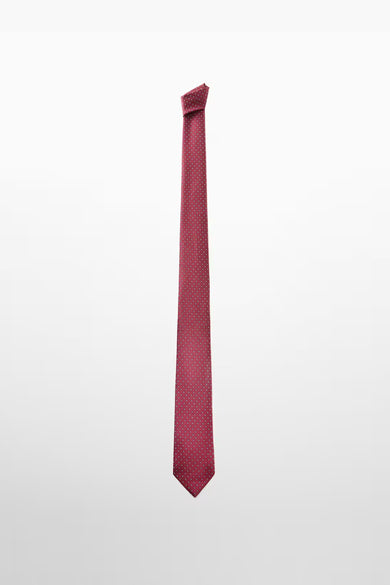 Cravate rouge à pois blancs de MANGO, accessoire élégant sur fond uni.