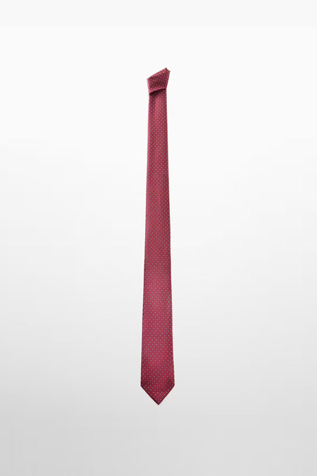 Cravate rouge à pois blancs de MANGO, accessoire élégant sur fond uni.