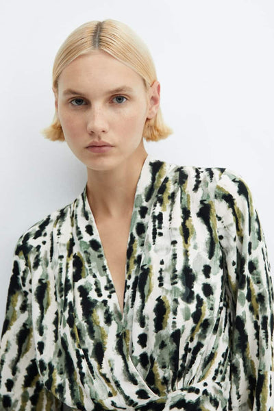 Robe midi multicolore de MANGO, imprimé tacheté vert et noir sur fond blanc, col cache-cœur.

