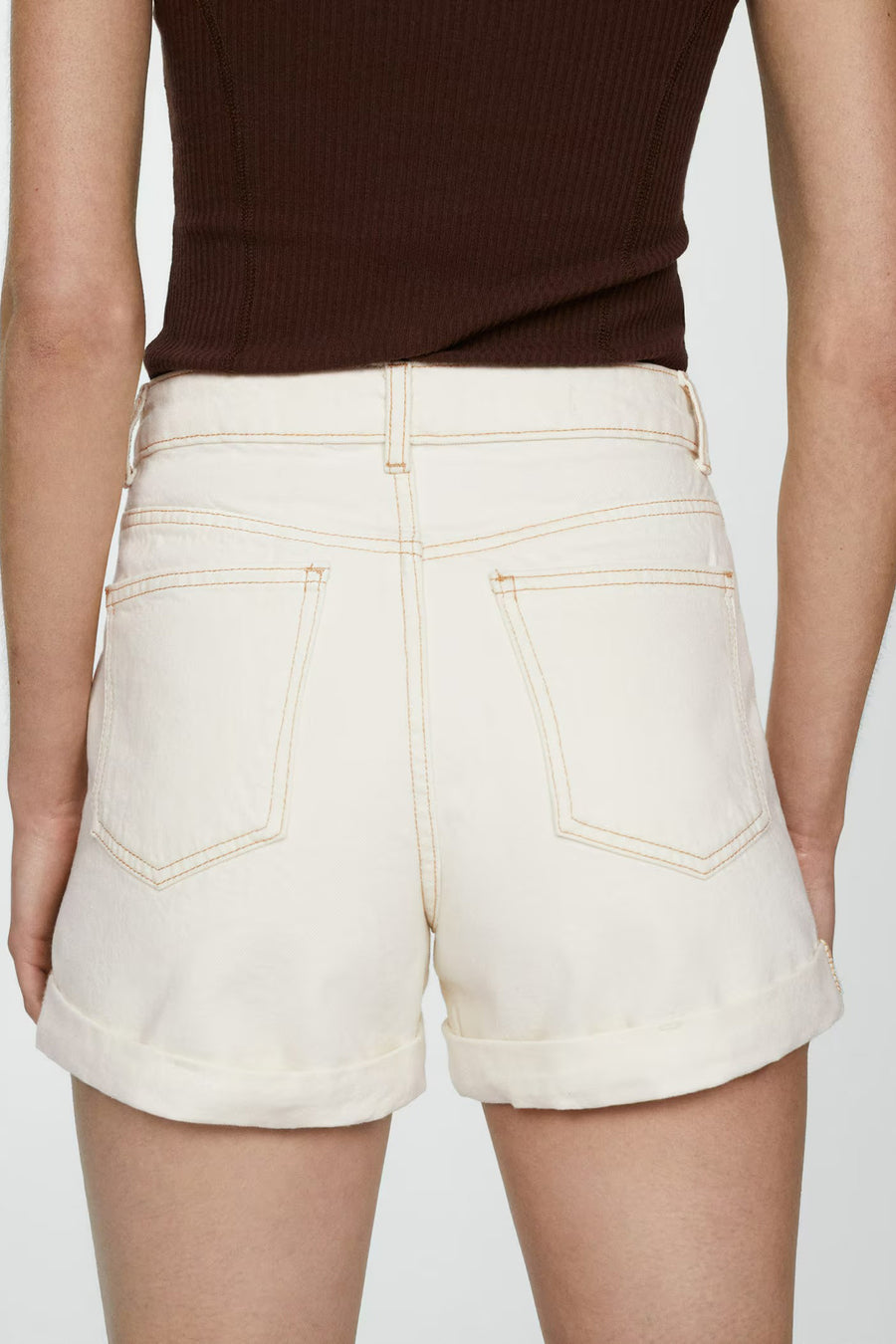 Korte beige short van MANGO, achterzijde, met contrasterende stiksels en omgeslagen zomen.
