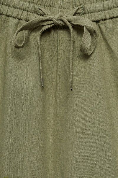Korte kaki van MANGO, detail van de strikceintuur met koord en linnen textuur.