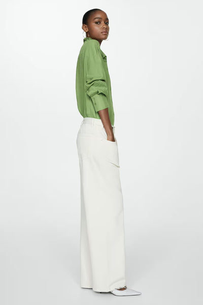 Groen overhemd met lange mouwen van MANGO, met knoopmanchetten en gedragen met een witte broek met hoge taille.
