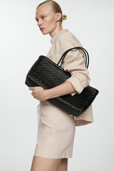 Korte beige short van MANGO, gedragen met een beige blouse en een zwarte gevlochten tas.