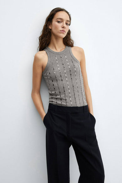 Débardeur gris côtelé de MANGO, orné de rangées verticales de sequins brillants, porté avec un pantalon noir.
