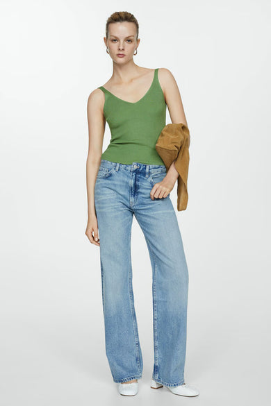 Débardeur vert de MANGO, côtelé, porté avec un jean bleu clair et une veste marron.