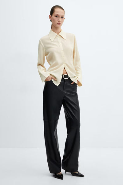 Chemisier à manches longues jaune de MANGO, porté avec un pantalon en similicuir noir et des chaussures pointues.
