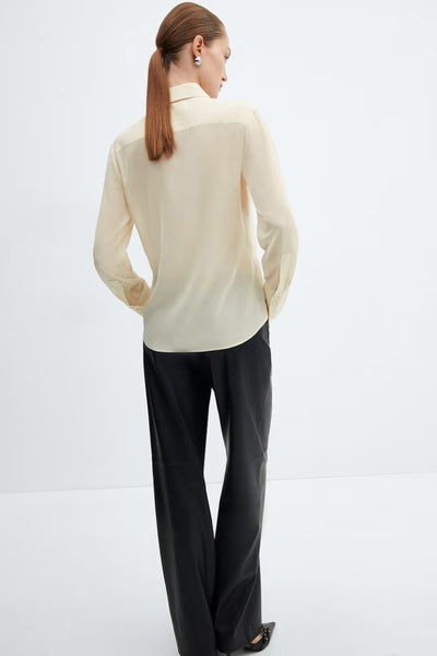 Chemisier à manches longues jaune de MANGO, porté avec un pantalon noir, vue de dos.