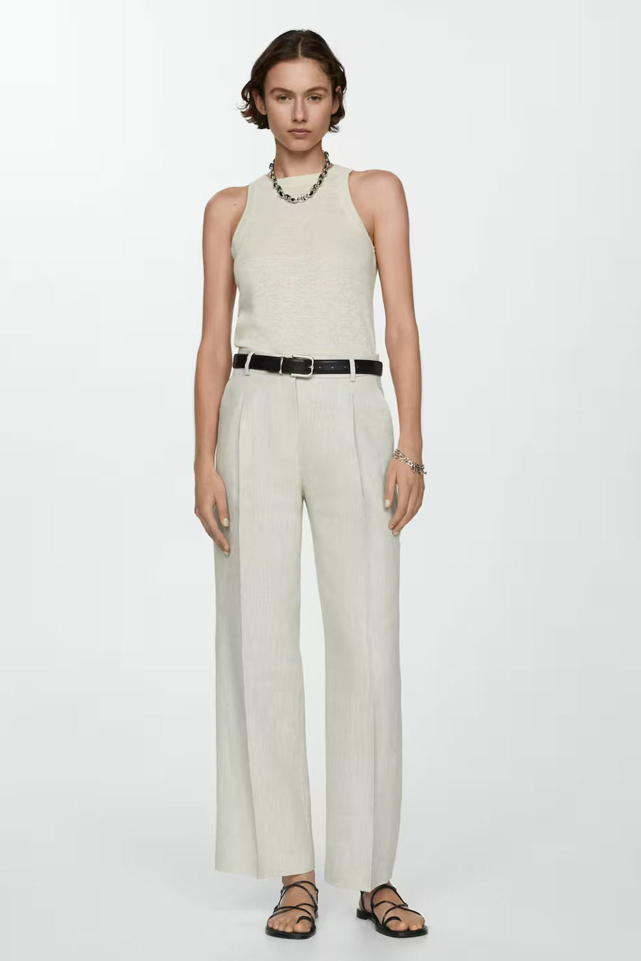 Beige tanktop van MANGO, gedragen met een broek met hoge taille en sandalen met bandjes.