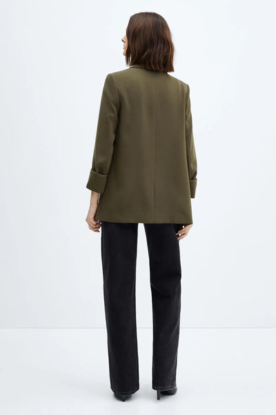 Blazer vert de MANGO, porté avec un jean noir coupe droite et des talons aiguilles, vue de dos.
