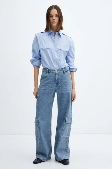 Jean droit en denim de MANGO, avec des poches cargo et porté avec une chemise rayée bleu clair.
