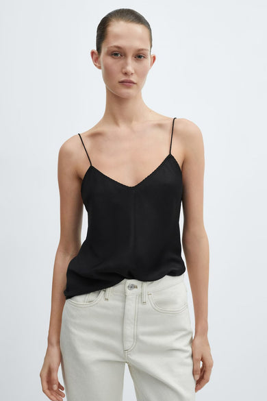 Top noir à fines bretelles de MANGO, porté avec un pantalon taille haute écru.