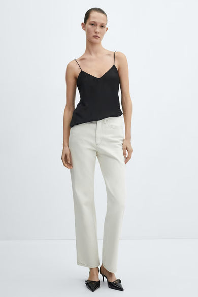 Top noir à fines bretelles de MANGO, porté avec un jean taille haute écru et des escarpins noirs vernis.
