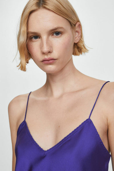 Top bleu à fines bretelles de MANGO, porté avec des cheveux blonds coupés courts.