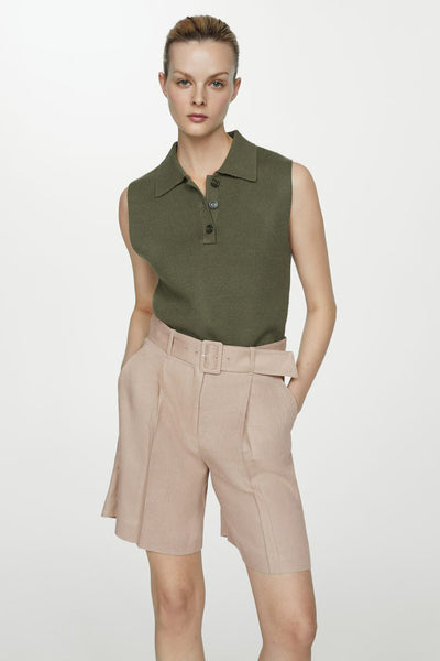 Short beige de MANGO, porté avec une ceinture à boucle assortie, poches et plis à l'avant.