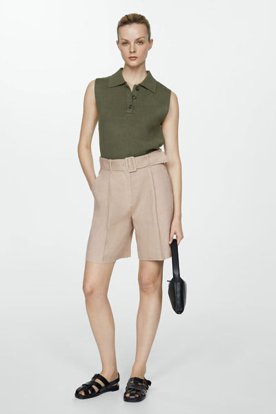 Short beige de MANGO, avec ceinture assortie, porté avec un haut vert olive et des sandales noires.

