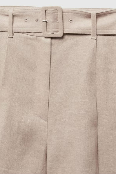 Short beige de MANGO avec ceinture assortie et plis structurés.
