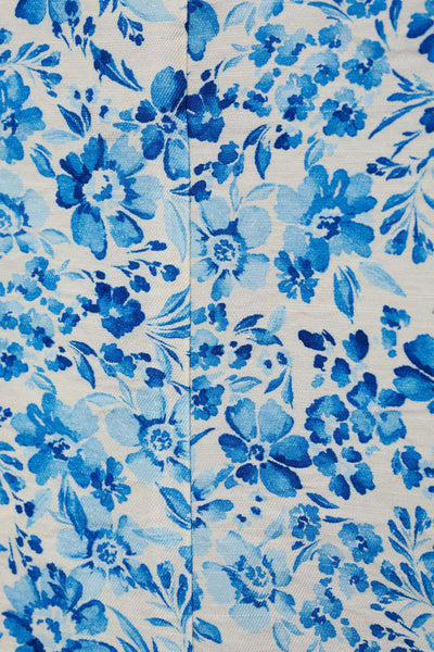 Short bleu de MANGO avec un motif floral bleu et des feuilles sur un fond blanc.