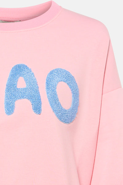 Roze Terra di Siena sweatshirt met blauwe "AO" bouclé-opdruk op de voorkant.