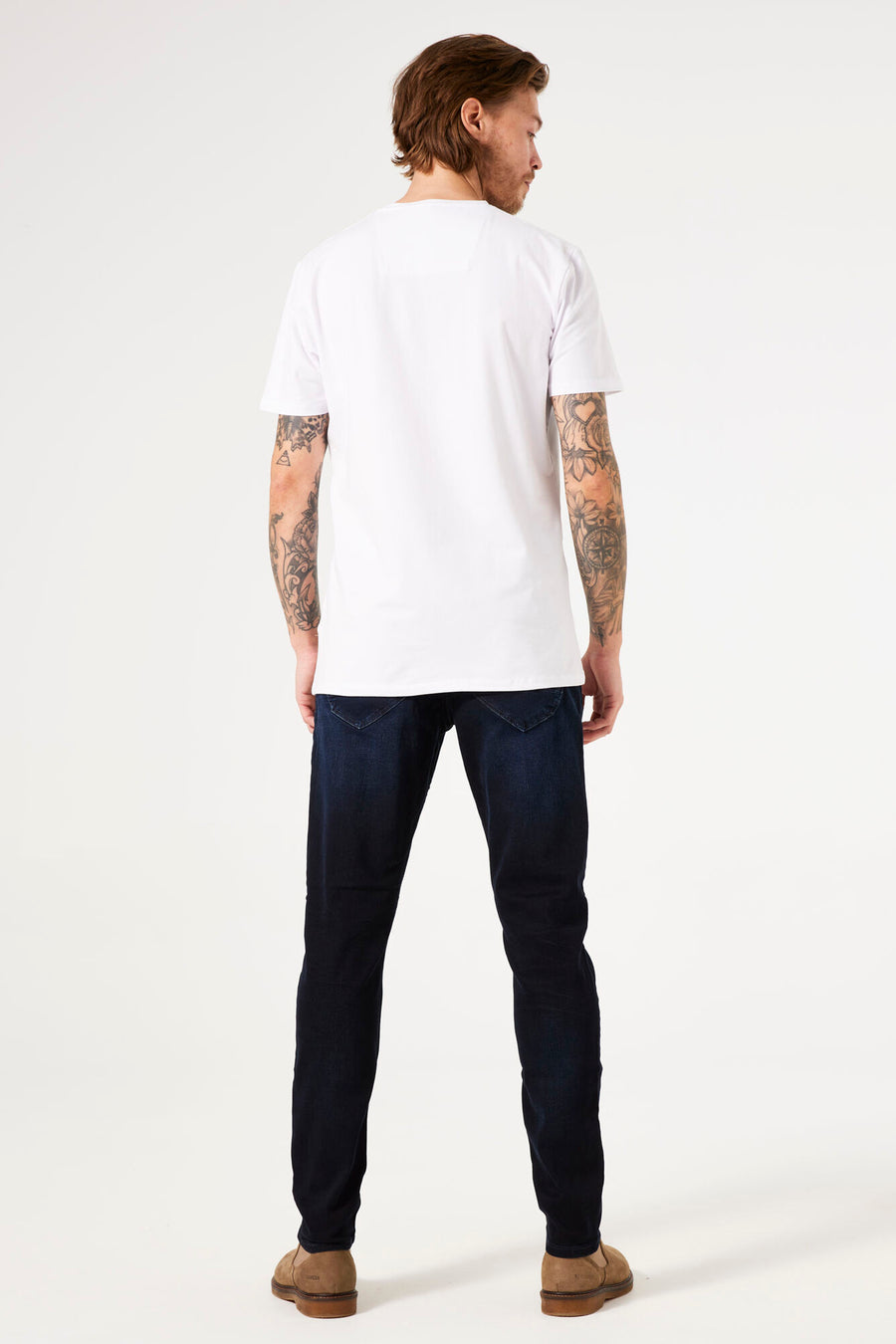 Jeans slim bleu foncé de GARCIA, vus de dos, portés avec un t-shirt blanc et des chaussures marron.