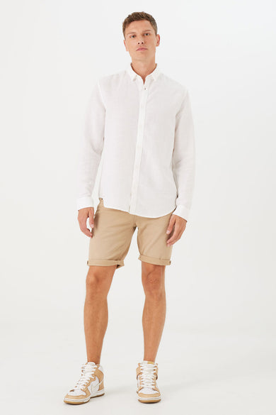 Short beige de GARCIA, porté avec une chemise blanche à manches longues et des baskets montantes.