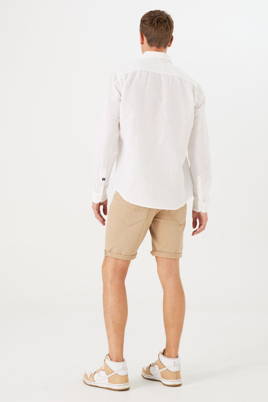 Short denim beige de GARCIA, avec ourlets retroussés, porté avec une chemise blanche et des baskets montantes.