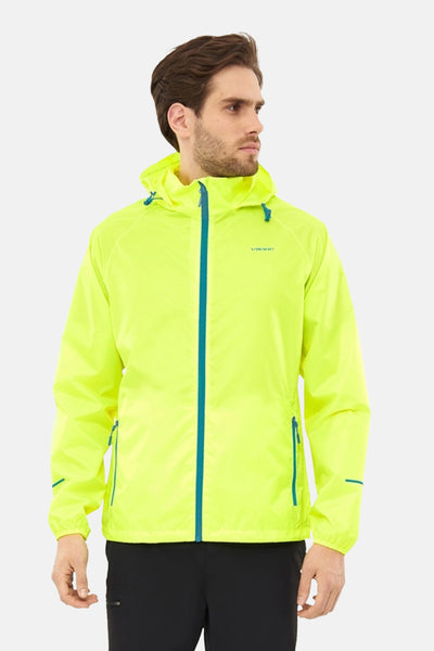 Gele VIKING jas, met capuchon en turquoise rits, gedragen met een zwarte broek.