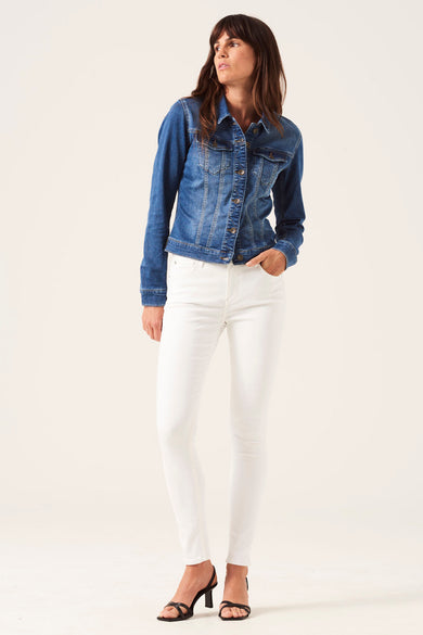 Veste en jean bleue de GARCIA, portée avec un pantalon blanc et des sandales noires à talons.