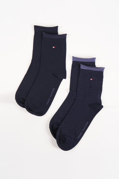Navy blue socks by Tommy Hilfiger, one pair solid knit, one with subtle dot texture and purple cuff, displayed flat on white background.