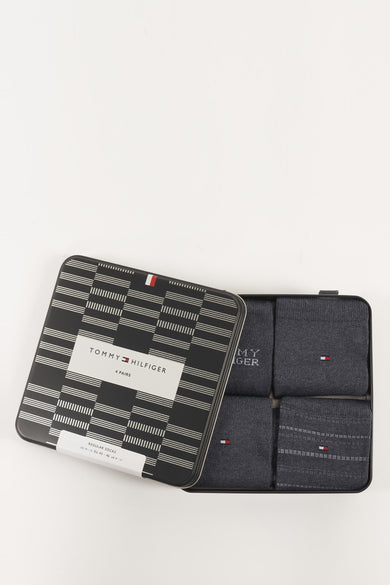 Coffret cadeau de quatre paires de chaussettes bleues par TOMMY JEANS dans une boîte métallique à rayures graphiques.