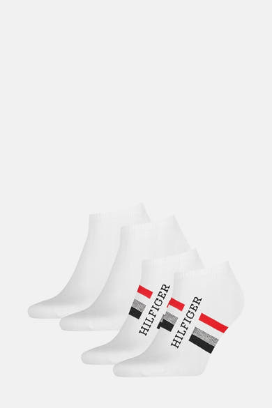 Chaussettes blanches par TOMMY JEANS avec rayures rouges et noires, logo Hilfiger imprimé sur le côté.