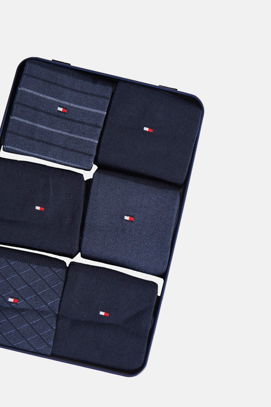 Chaussettes bleues par TOMMY JEANS, assortiment de motifs divers présentées dans une boîte rigide bleue.
