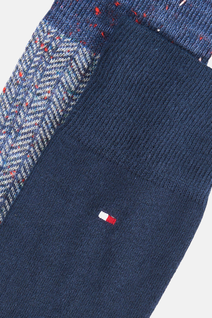 Gros plan sur une chaussette courte bleu marine TOMMY JEANS, avec motif contrastant et logo brodé.
