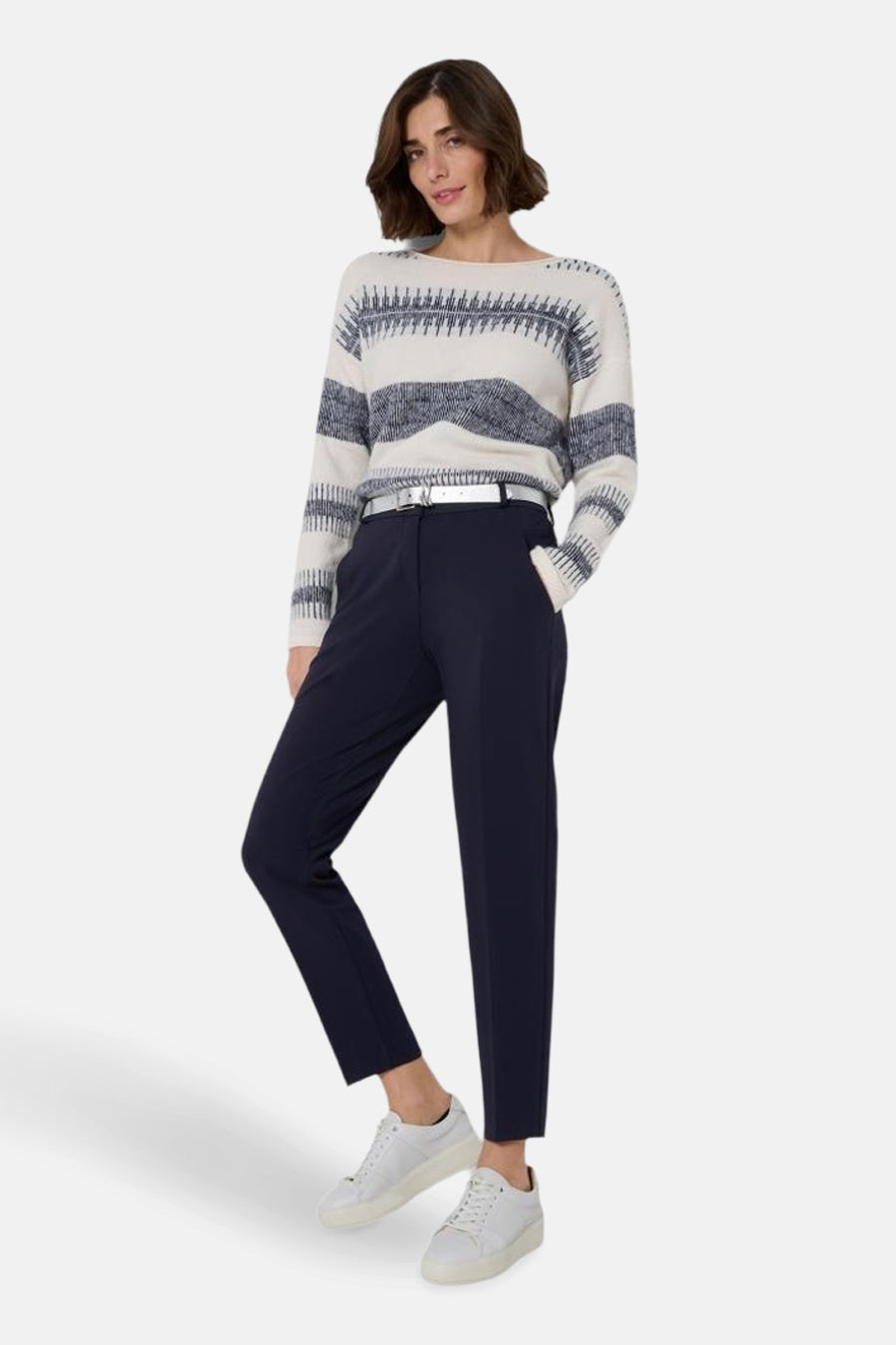 Pantalon de costume bleu marine de BRAX, porté avec un pull à rayures et des baskets blanches.
