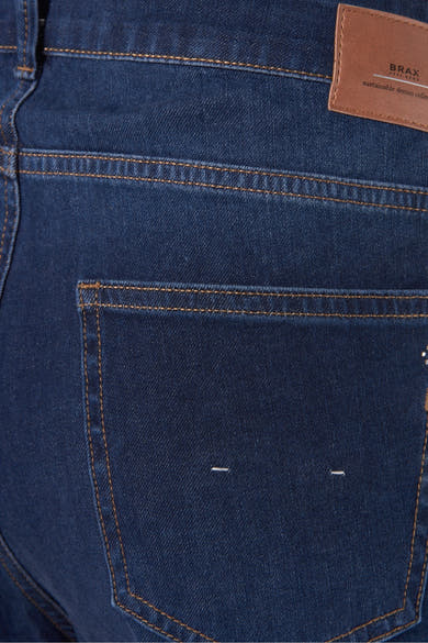Jean slim en denim bleu par BRAX, avec surpiqûres contrastantes et poche arrière minimaliste.