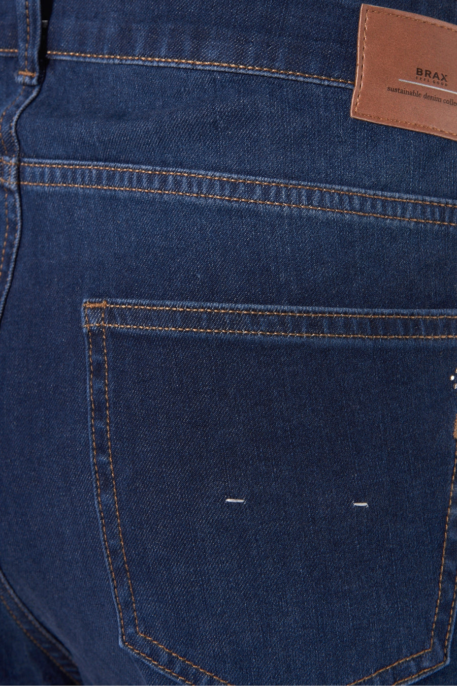 Jean slim en denim bleu par BRAX, avec surpiqûres contrastantes et poche arrière minimaliste.
