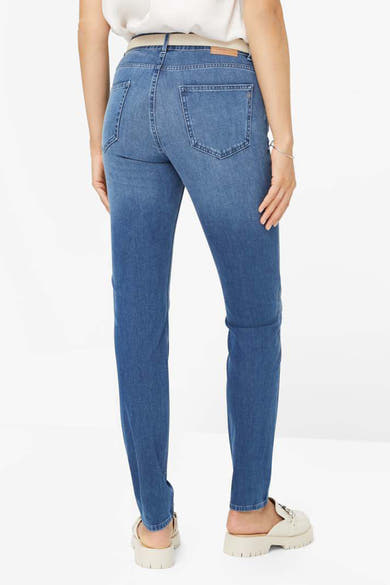 Jean slim en denim bleu moyen de Brax, vue arrière, avec poches et chaussures beiges assorties.