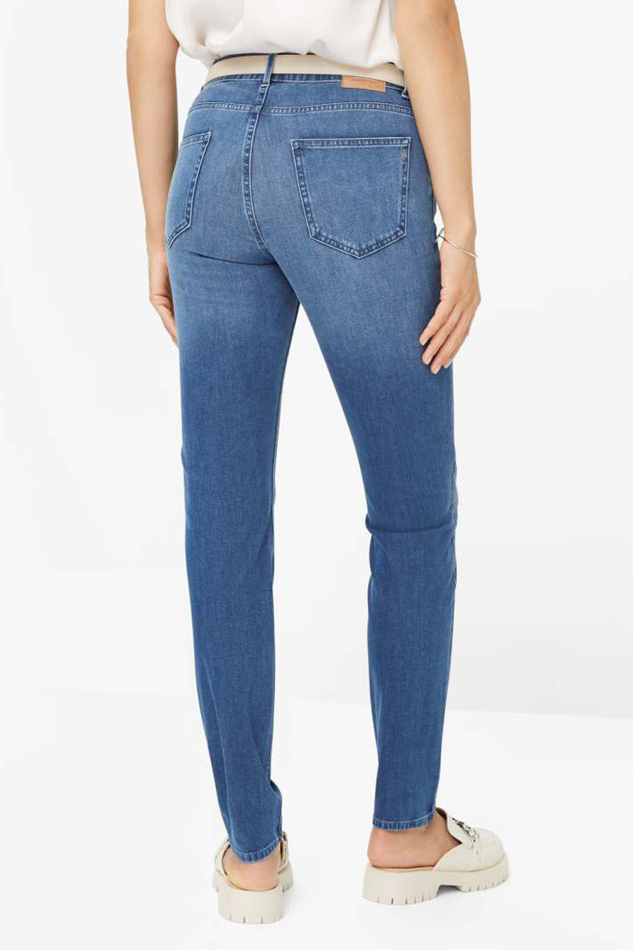Jean slim en denim bleu moyen de Brax, vue arrière, avec poches et chaussures beiges assorties.