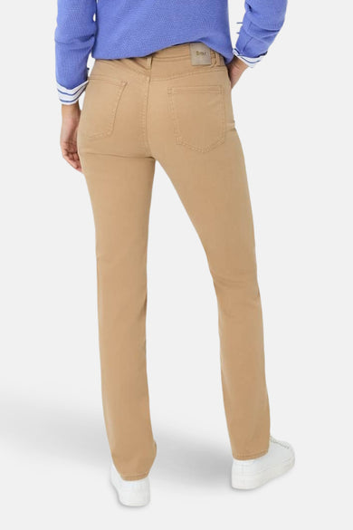 Rechte broek in camelkleur van BRAX, met achterzakken en gedragen met een blauwe trui.