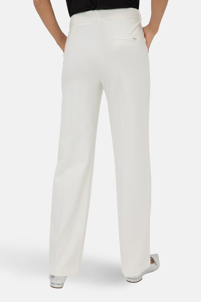 Witte kostuumbroek van BRAX, losse pasvorm, met zijzakken en een zoom die over zilveren schoenen valt.