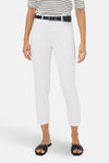 Slim jeans van witte denim van Brax, gedragen met een marineblauwe riem en zwarte sandalen.