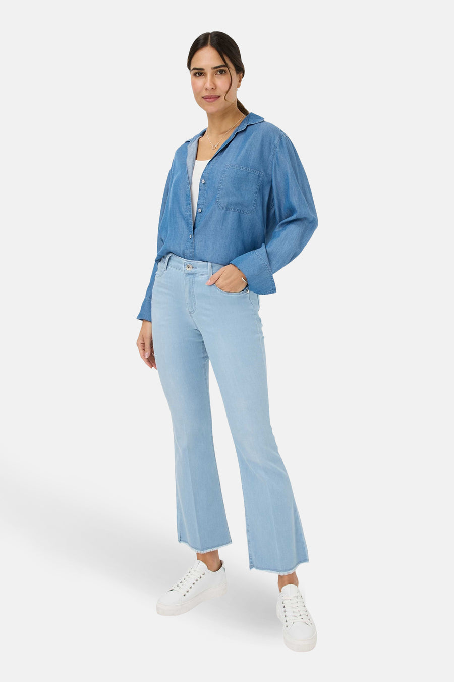 Jean slim en denim blanc de BRAX, porté avec une chemise en jean et des baskets blanches.
