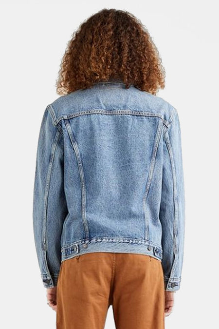 Veste en denim bleu de Levi's, vue de dos, portée avec un pantalon marron.