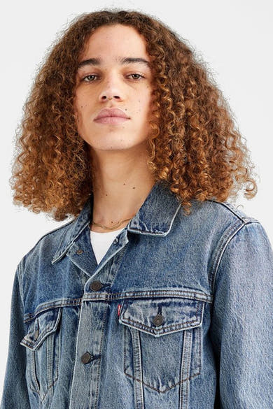 Veste en denim bleu de Levi's® avec boutons et poches à rabat, portée sur un t-shirt blanc.
