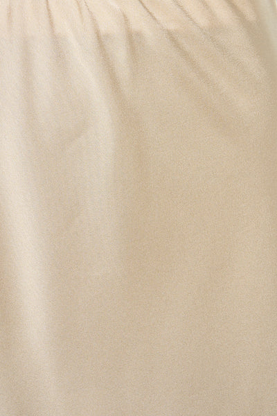 Jupe longue beige de Terra di Siena, tissu texturé avec quelques plis et reflets subtils.