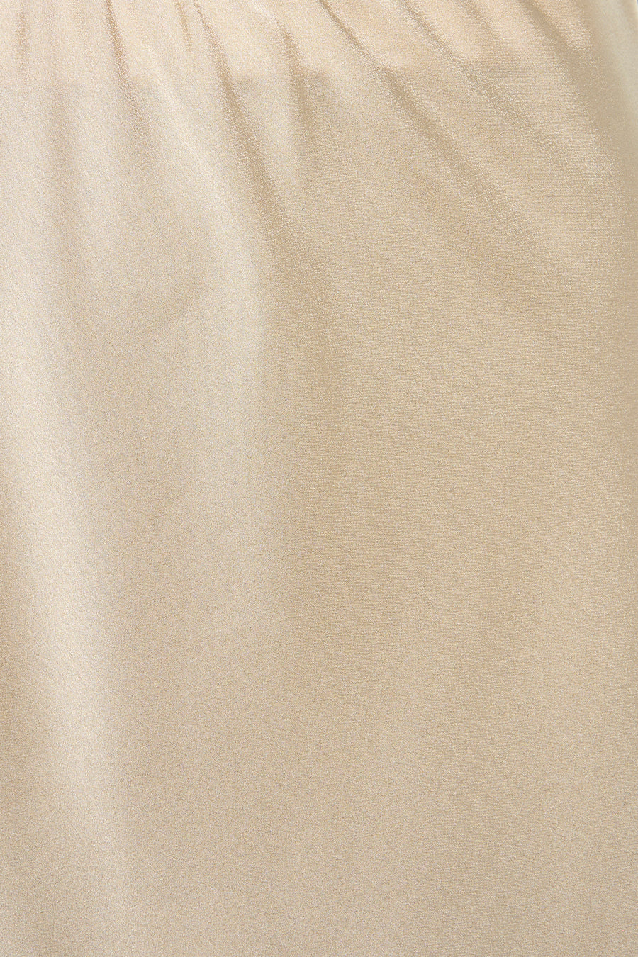 Jupe longue beige de Terra di Siena, tissu texturé avec quelques plis et reflets subtils.